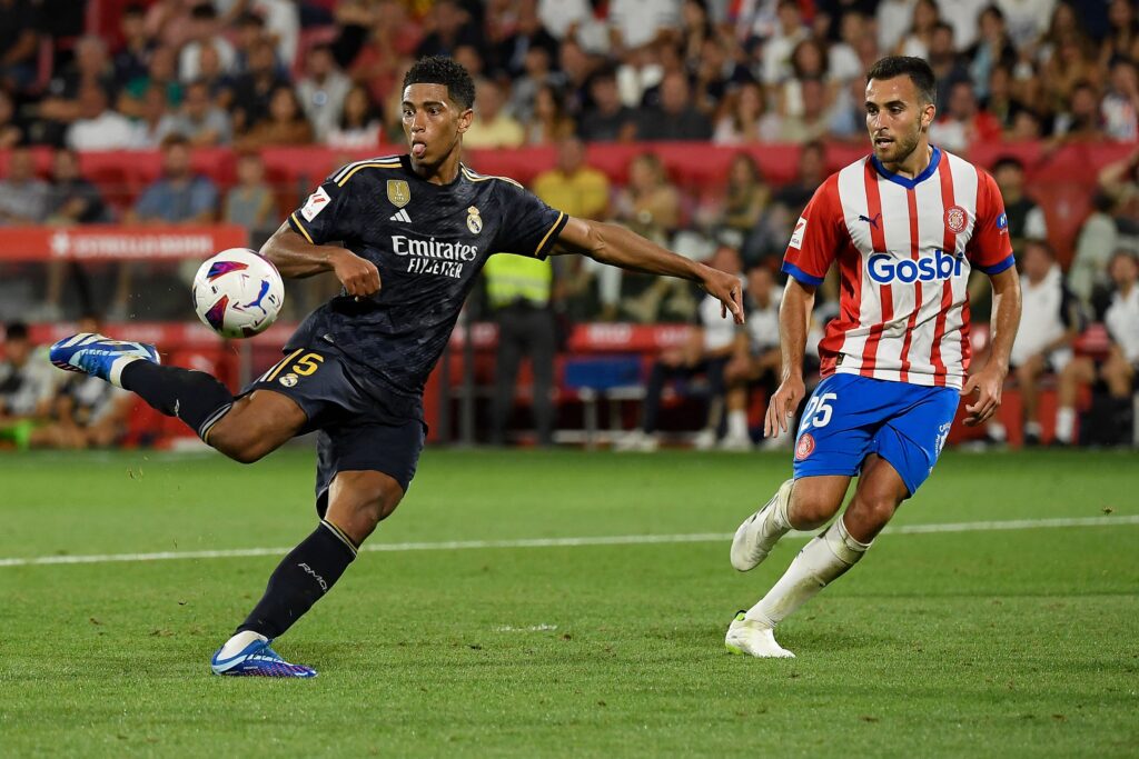 Real Madrid's English midfielder #5 Jude Bellingham kicks the ball and scores his team's third goal during the Spanish Liga football match between Girona FC and Real Madrid CF at the Montilivi stadium in Girona on September 30, 2023.