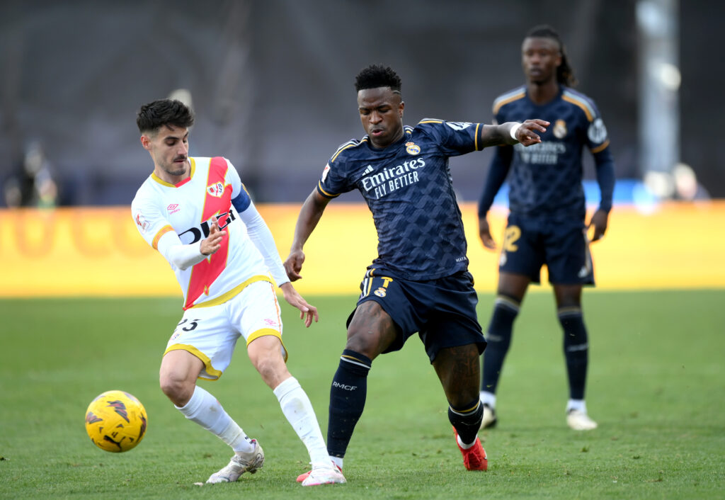 MADRID, SPAIN - FEBRUARY 18: Oscar Valentin of Rayo Vallecano battles for possession with Vinicius Junior of Real Madrid during the LaLiga EA Sports match between Rayo Vallecano and Real Madrid CF at Estadio de Vallecas on February 18, 2024 in Madrid, Spain.