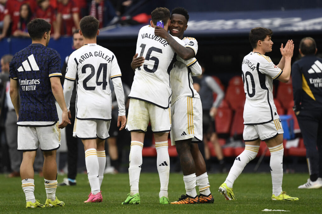 Real Madrid's Brazilian forward #07 Vinicius Junior (2R) celebrates their victory with teammates at the end of the Spanish league football match between CA Osasuna and Real Madrid CF at El Sadar stadium in Pamplona on March 16, 2024.