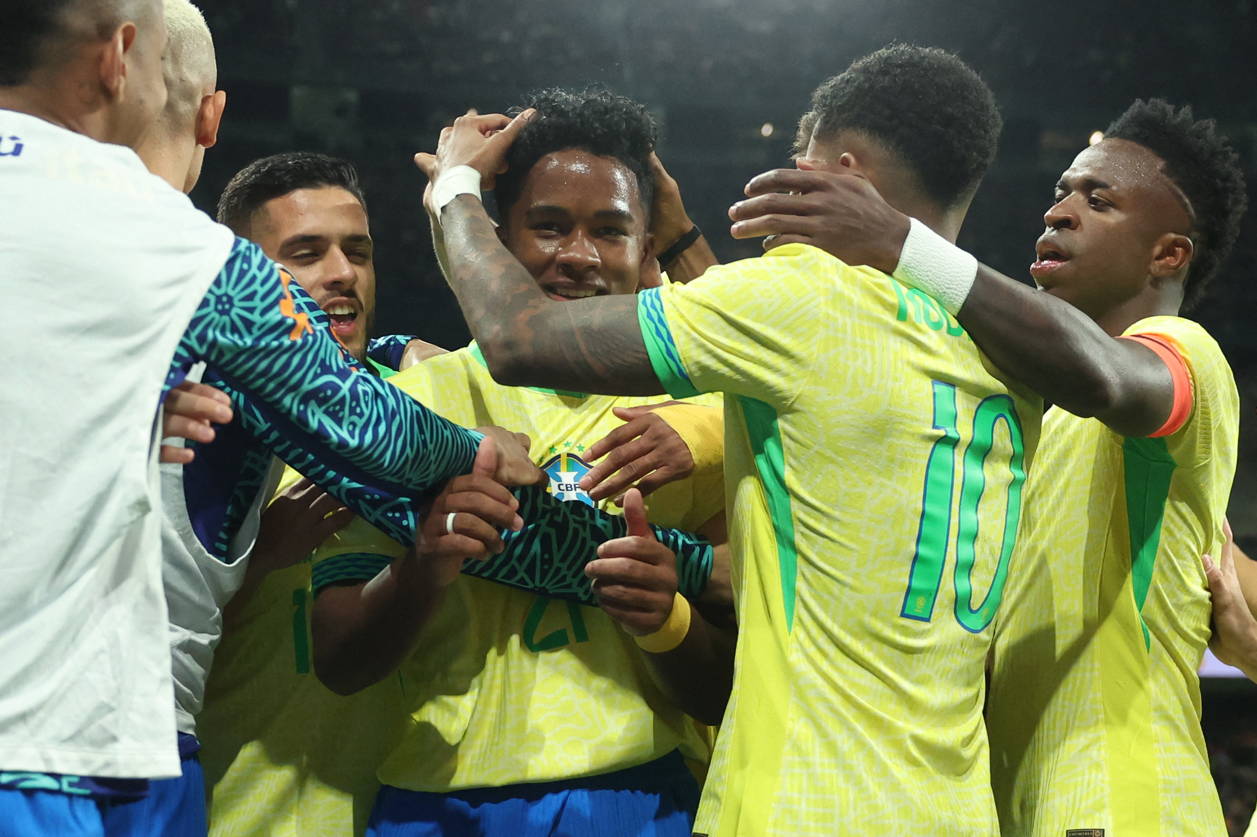 TOPSHOT - Brazil's forward #21 Endrick celebrates with teammates scoring his team's second goal during the international friendly football match between Spain and Brazil at the Santiago Bernabeu stadium in Madrid, on March 26, 2024. Spain arranged a friendly against Brazil at the Santiago Bernabeu under the slogan 
