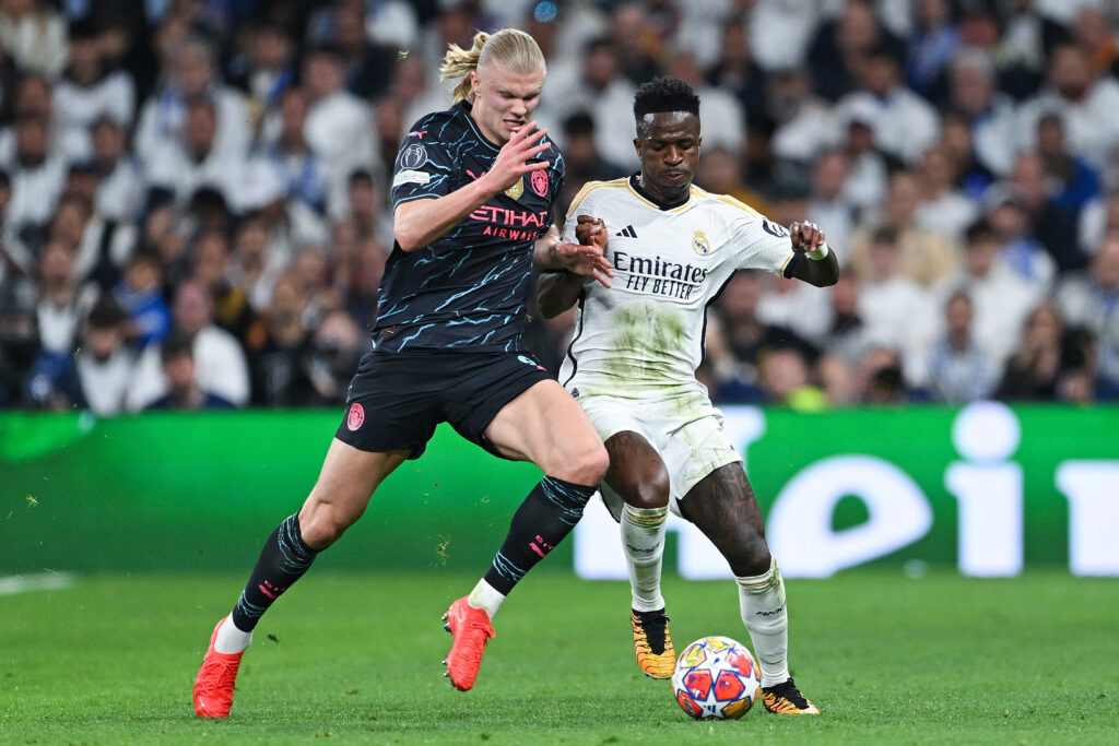 MADRID, SPAIN - APRIL 09: Vinicius Jr. of Real Madrid CF competes for the ball with Erling Haaland of Manchester City during the UEFA Champions League quarter-final first leg match between Real Madrid CF and Manchester City at Estadio Santiago Bernabeu on April 09, 2024 in Madrid, Spain.