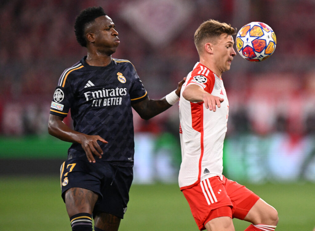 Real Madrid's Brazilian forward #07 Vinicius Junior and Bayern Munich's German midfielder #06 Joshua Kimmich vie for the ball during the UEFA Champions League semi-final first leg football match between FC Bayern Munich and Real Madrid CF on April 30, 2024 in Munich, southern Germany.