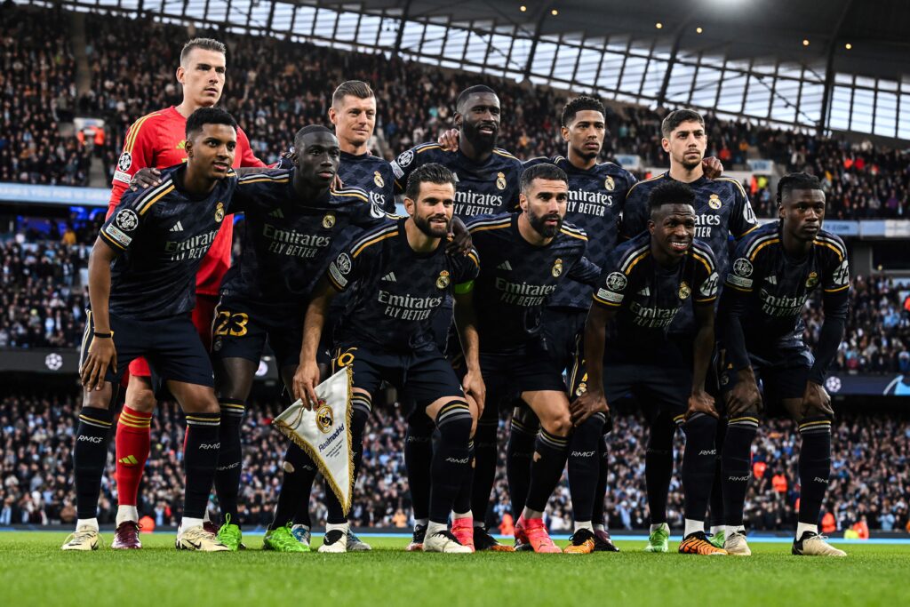 (front row from L to R) Real Madrid's Brazilian forward #11 Rodrygo, Real Madrid's French defender #23 Ferland Mendy, Real Madrid's Spanish defender #06 Nacho Fernandez Real Madrid's Spanish defender #02 Dani Carvajal, Real Madrid's Brazilian forward #07 Vinicius Junior, Real Madrid's French midfielder #12 Eduardo Camavinga (back row from L to R) Real Madrid's Ukrainian goalkeeper #13 Andriy Lunin, Real Madrid's German midfielder #08 Toni Kroos, Real Madrid's German defender #22 Antonio Rudiger, Real Madrid's English midfielder #5 Jude Bellingham and Real Madrid's Uruguayan midfielder #15 Federico Valverde pose for team photo during the UEFA Champions League quarter-final second-leg football match between Manchester City and Real Madrid, at the Etihad Stadium, in Manchester, north-west England, on April 17, 2024.