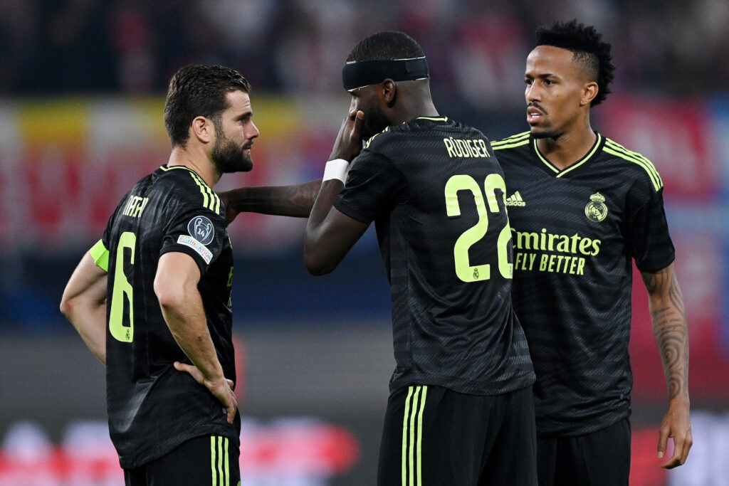 LEIPZIG, GERMANY - OCTOBER 25: Nacho Fernandez speaks with Antonio Rudiger and Eder Militao of Real Madrid during the UEFA Champions League group F match between RB Leipzig and Real Madrid at Red Bull Arena on October 25, 2022 in Leipzig, Germany.