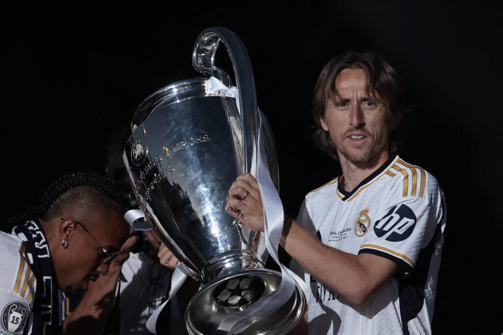 Real Madrid's Croatian midfielder #10 Luka Modric celebrates with the trophy their 15th Champions League win, one day after beating Borussia Dortmund in London, on Cibeles square in Madrid on June 2, 2024.