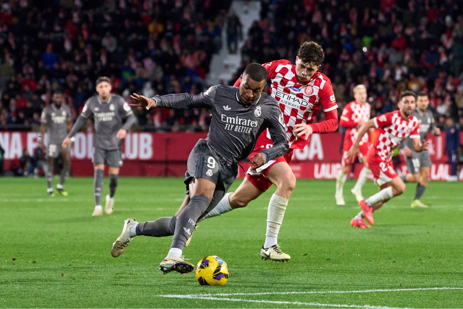 GIRONA, SPAIN - DECEMBER 07: Kylian Mbappe of Real Madrid CF runs with the ball whilst under pressure from Ladislav Krejci of Girona FC during the LaLiga match between Girona FC and Real Madrid CF at Montilivi Stadium on December 07, 2024 in Girona, Spain.