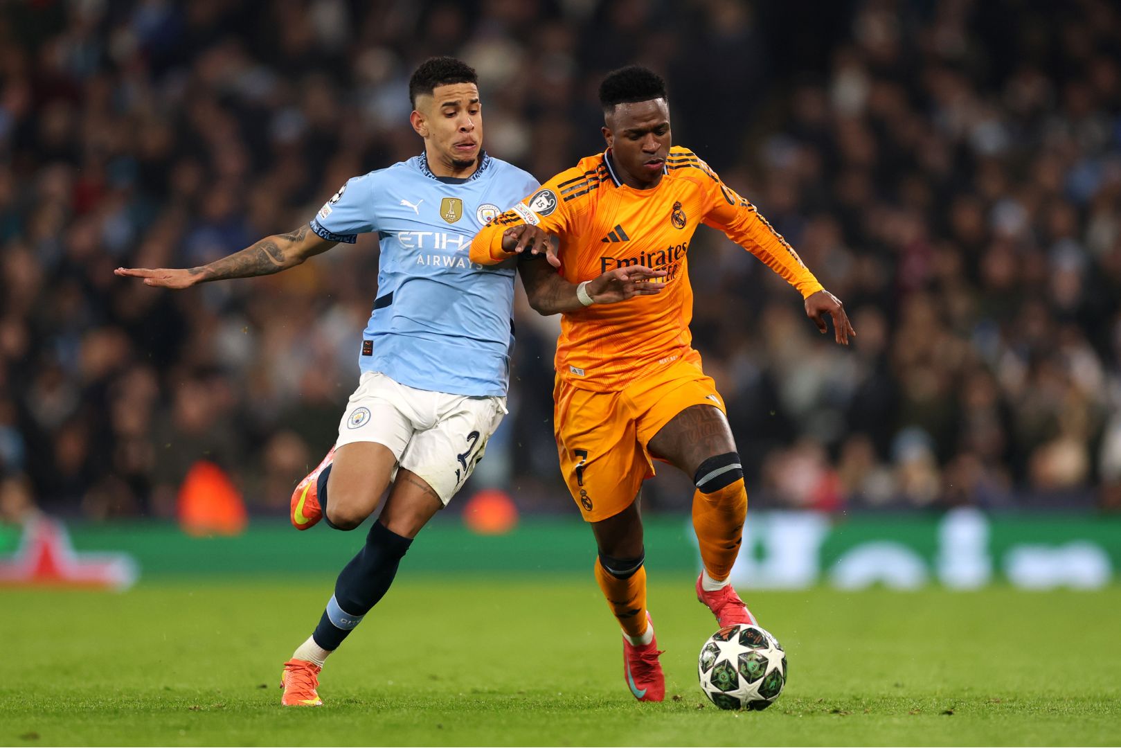 MANCHESTER, ENGLAND - FEBRUARY 11: Vinicius Junior of Real Madrid is challenged by Savinho of Manchester City during the UEFA Champions League 2024/25 League Knockout Play-off first leg match between Manchester City and Real Madrid C.F. at Manchester City Stadium on February 11, 2025 in Manchester, England.