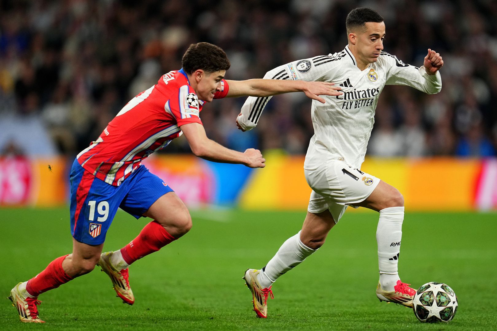 MADRID, SPAIN - MARCH 04: Lucas Vazquez of Real Madrid runs with the ball whilst under pressure from Julian Alvarez of Atletico de Madrid during the UEFA Champions League 2024/25 Round of 16 first leg match between Real Madrid C.F. and Atletico de Madrid at Santiago Bernabeu Stadium on March 04, 2025 in Madrid, Spain.