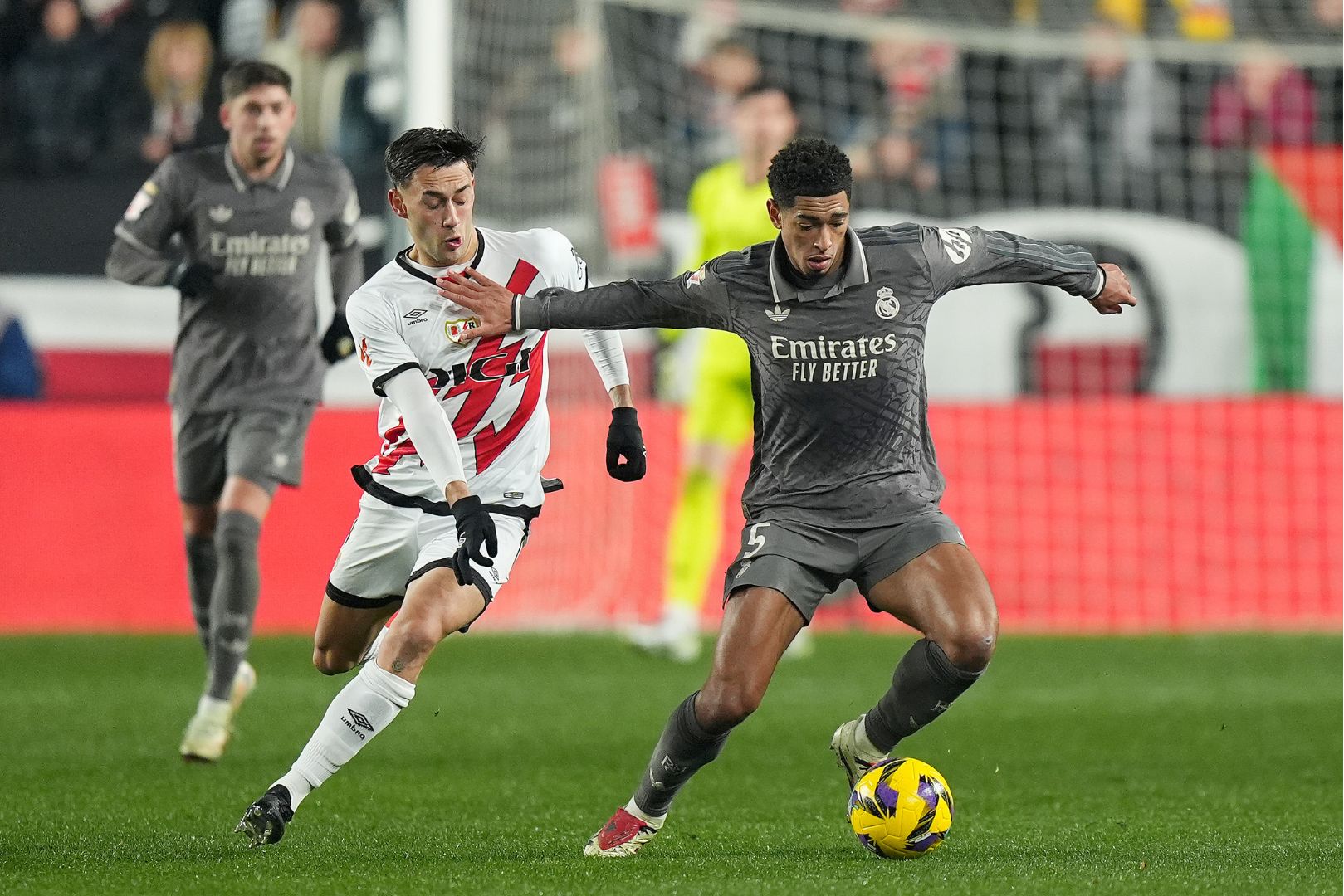 MADRID, SPAIN - DECEMBER 14: Jude Bellingham of Real Madrid controls the ball under pressure from Pedro Diaz of Rayo Vallecano during the LaLiga EA Sports match between Rayo Vallecano and Real Madrid at Estadio de Vallecas on December 14, 2024 in Madrid, Spain.